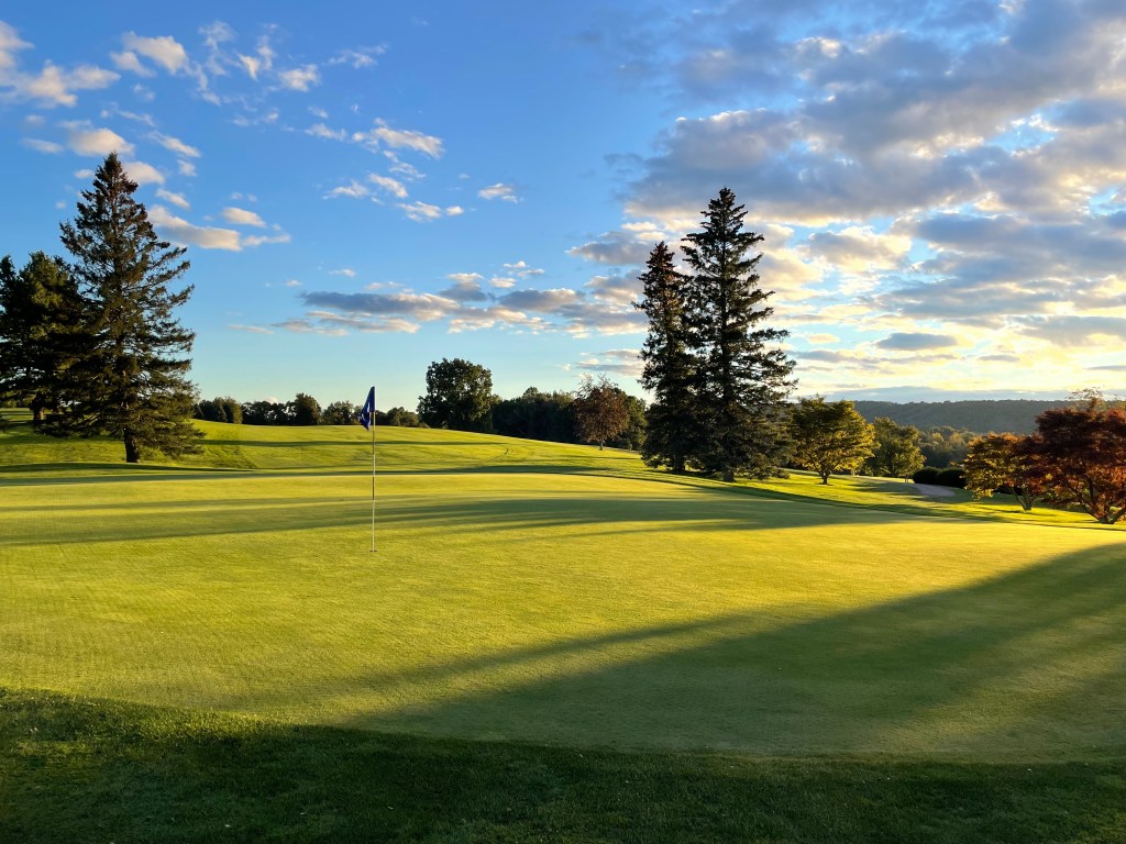 View of golf course green at sunset